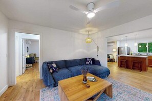 Ein modernes Wohnzimmer mit Sofa, Couchtisch und Küchenbereich mit Bar.