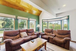 Ein Wohnzimmer mit zwei Ledersofas, einem Holztisch und einer Lampe.