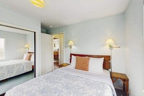 A hotel room with a large bed, two bedside tables, and a mirror. - Seascape Home & Cottage (Trinidad)