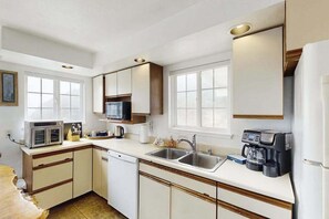 A compact kitchen with a microwave, coffee maker, and a sink. - Seascape Home & Cottage (Trinidad)