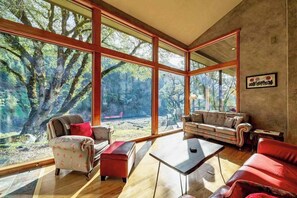 A spacious living area with large windows, a sofa set, and a coffee table.