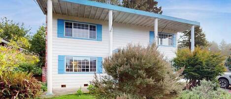 A two-story house with a covered porch and a well-maintained lawn.
