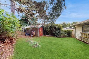 A residential backyard with a small shed, a lawn, and a house. - Eureka Charmer - Cozy Historic Getaway in the Heart of Town (Eureka)