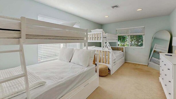 A bedroom with bunk beds, a dresser, a mirror, and a window with blinds. - Pacific View Escape - Stunning Ocean Views & Coastal Comfort (Crescent City)