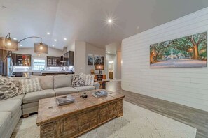 A modern living room with a sofa, coffee table, and artwork on the wall. - Mojo's Dojo - Unique Coastal Hideaway with a Fun, Relaxed Vibe (McKinleyville)