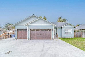 A single-story house with a garage, a covered driveway, and a small front yard. - Mojo's Dojo - Unique Coastal Hideaway with a Fun, Relaxed Vibe (McKinleyville)