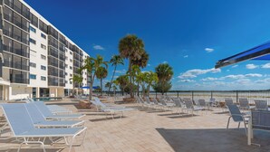 A rooftop pool area with sun loungers and palm trees, overlooking a clear blue sky. - ⛱️ Coastal Views | Beachfront Location | Paradise Point–Carlos Pointe #213 🌊 (Fort Myers Beach)