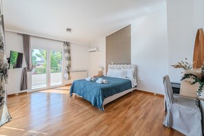 A bedroom with a bed, a radiator, a television, and a view of the outdoors. - Casa Panorama in Voula - Panoramic Sea View Villa (Voula)