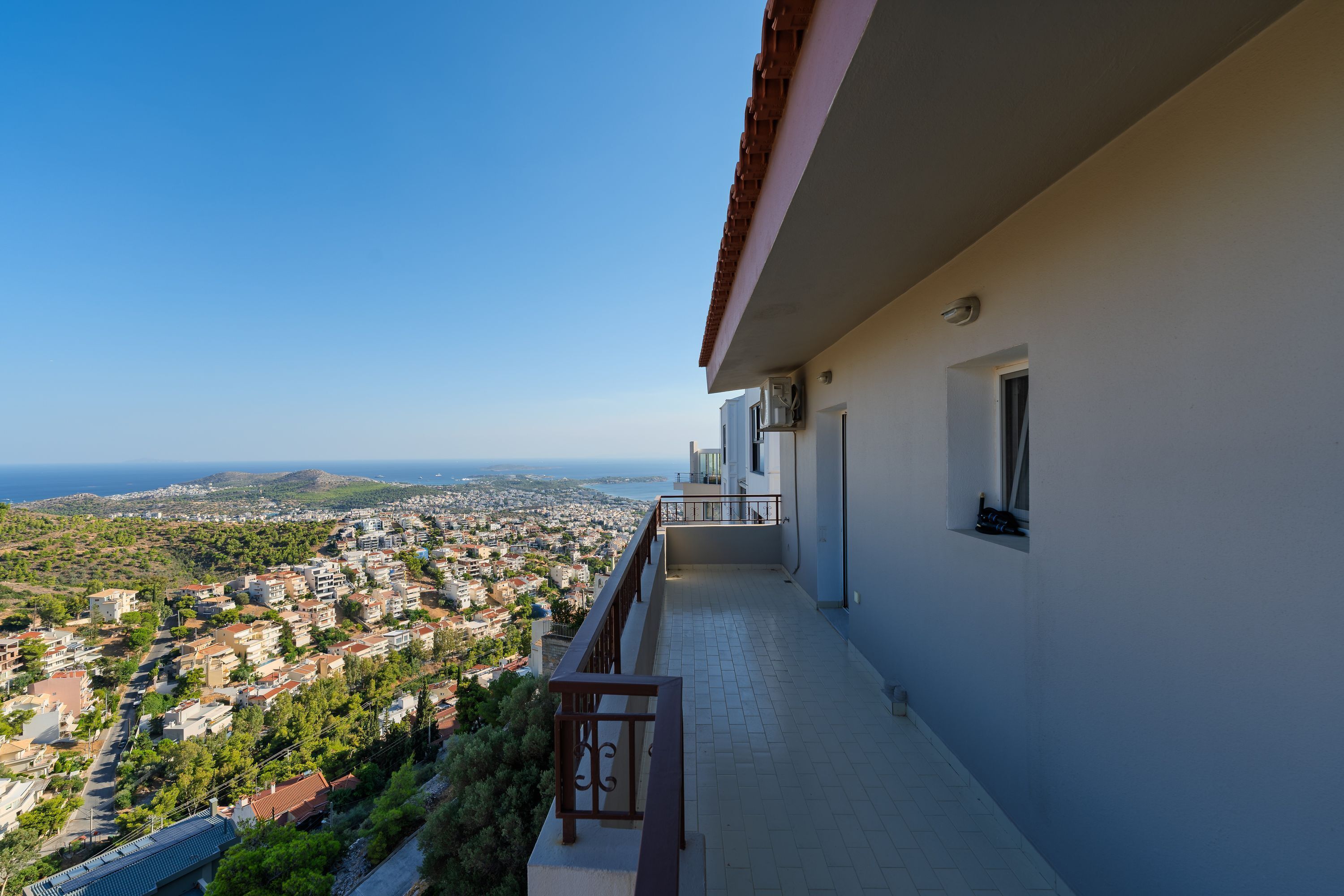 Un balcon avec vue sur une ville côtière et la mer.