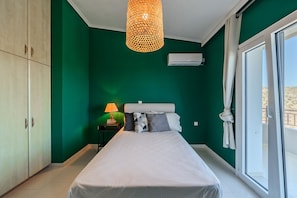 Une chambre à coucher avec un lit, une table de chevet, une lampe, une armoire et une fenêtre avec des rideaux.