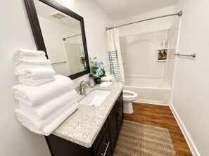 A bathroom with a sink, mirror, stacked towels, a shower, and a toilet. - 4b2b with AC and large deck Queen Anne Seattle (Seattle)