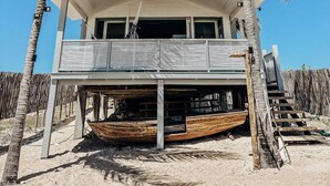 A beachfront property with a two-story structure, a covered deck, and a boat dock. - Uba House in Icaraizinho/CE - Beachfront - infinity pool - right on the sand (Icarai)