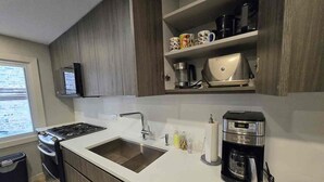 Una cucina moderna con piano cottura integrato, lavello e macchina da caffè.
