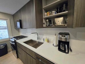 A modern kitchen with a built-in stove, a sink, and a coffee maker. - Wonderful townhome East Lakeview near cubs 5 min walk to lake in vibrant Chicago (Chicago)