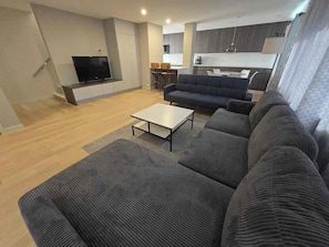 A modern living room with a sofa, a coffee table, and a TV. - Wonderful townhome East Lakeview near cubs 5 min walk to lake in vibrant Chicago (Chicago)