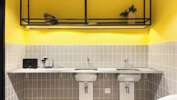 A bathroom with two sinks, a towel rack, and a shelf above the sinks.
