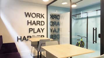 A modern office space with a glass wall, a wooden table, and a bicycle.