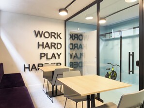 A modern office space with a glass wall, a wooden table, and a bicycle. - OY Campo Belo (São Paulo)