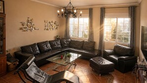 A living room with a sectional sofa, a chaise lounge, a coffee table, and a TV.
