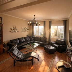 A living room with a sectional sofa, a chaise lounge, a coffee table, and a TV.