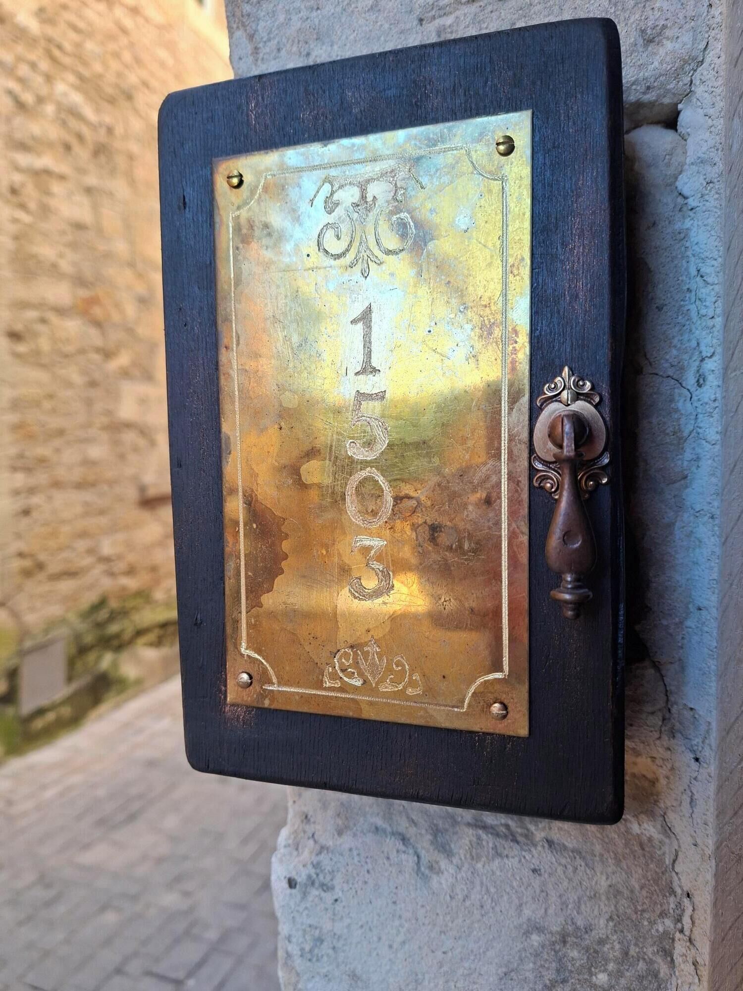 A metal plaque with numbers '1 3 0 3' mounted on a wall.