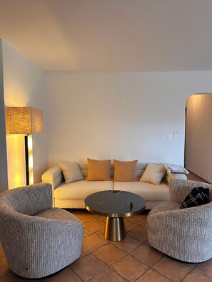 A modern living room with a sofa, two ottomans, a round coffee table, and a floor lamp. - Near Saint Tropez Charming 4 bedroom house swimming pool garden  with AC (La Croix-Valmer)