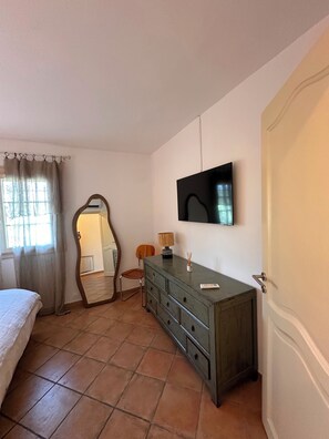 A bedroom with a bed, a dresser, a chair, a mirror, and a TV on the wall. - Near Saint Tropez Charming 4 bedroom house swimming pool garden  with AC (La Croix-Valmer)