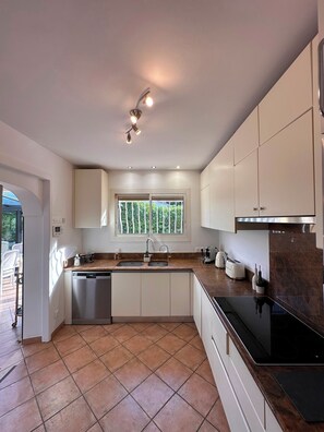 A modern kitchen with a dishwasher, double sink, and a large island with a stove. - Near Saint Tropez Charming 4 bedroom house swimming pool garden  with AC (La Croix-Valmer)