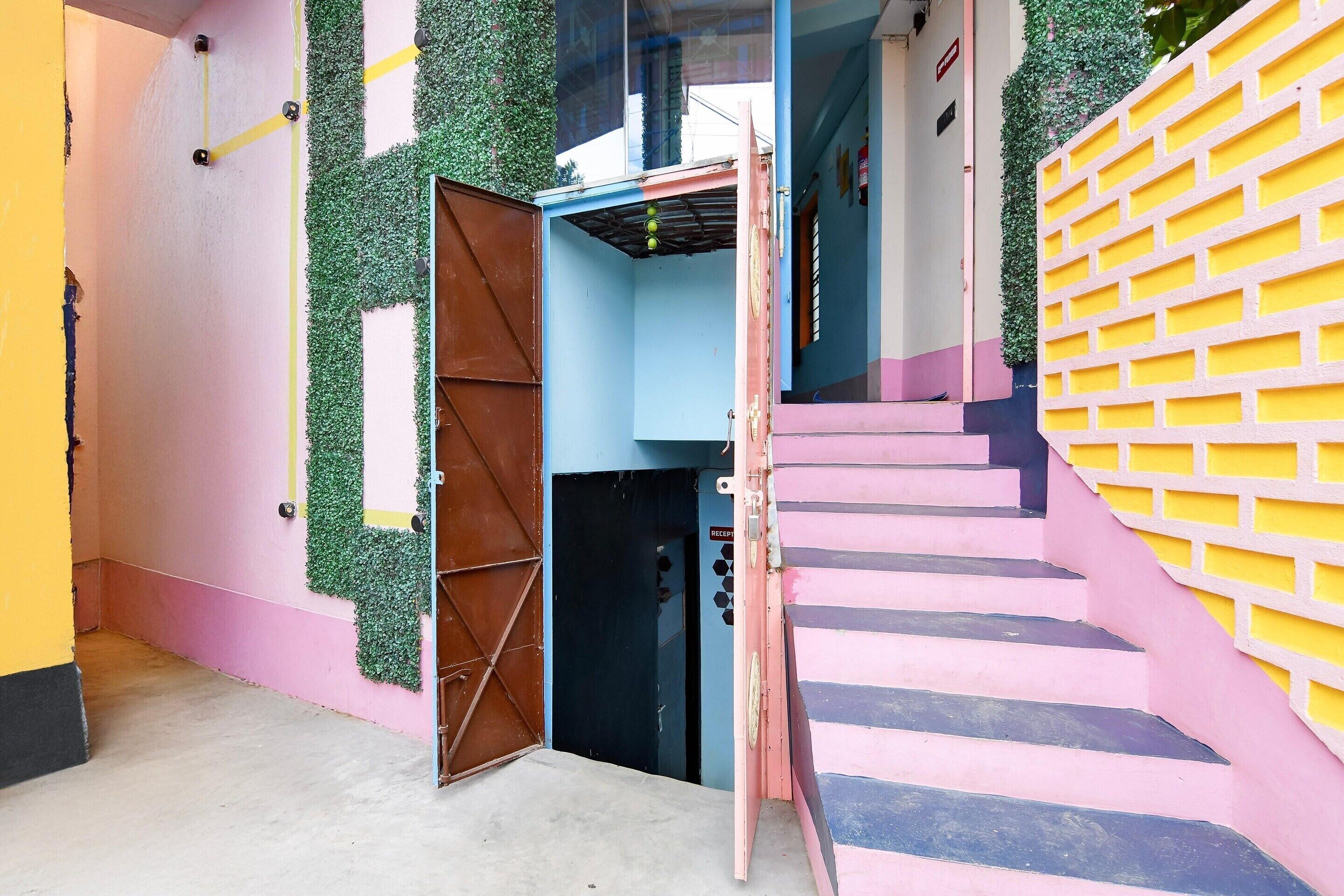 A multi-level building with a staircase, a reception area, and a door with a metal gate.