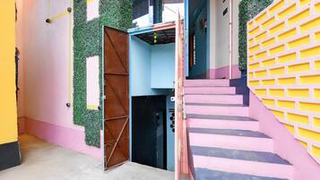 A multi-level building with a staircase, a reception area, and a door with a metal gate.