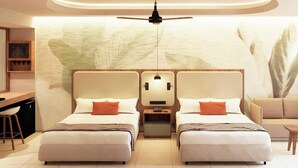 Quarto de hotel com duas camas, uma mesa, uma cadeira e um sofá.