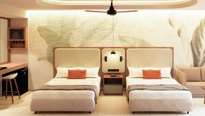 Quarto de hotel com duas camas, uma mesa, uma cadeira e um sofá.