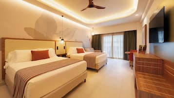 Une chambre d’hôtel avec deux lits, un ventilateur de plafond, une télévision et une grande fenêtre avec des rideaux.