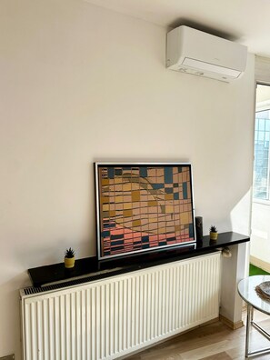 A room with a radiator, a black shelf with a decorative item, and a window with a view. - Warsaw Core 3-bedrooms apartment in City Center, Pet Friendly (Warszawa)