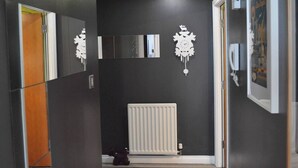 Ein Flur mit Heizkörper, Tür und Kleiderständer.