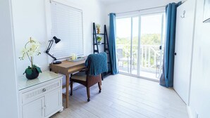 A room with a wooden desk, a chair, a white dresser, a window with blinds, a ceiling fan, and a view of greenery outside. - Lakeview House with Pool, BBQ, and Backyard (Venetian Road Settlement)