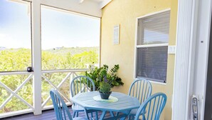 A covered outdoor seating area with a table and chairs, a potted plant, and a view of a landscape. - Lakeview House with Pool, BBQ, and Backyard (Venetian Road Settlement)