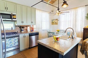 A kitchen with a central island, stainless steel appliances, and a ceiling fan. - Lake View Home w/ BBQ, Pool and Outdoor Deck (Venetian Road Settlement)