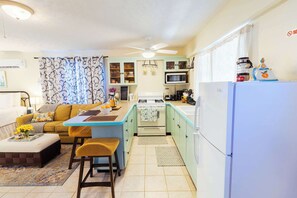 A compact kitchen with a dining area, a sofa, and a coffee table. - Island Studio with Pool Access, Porch & Workspace (Venetian Road Settlement)