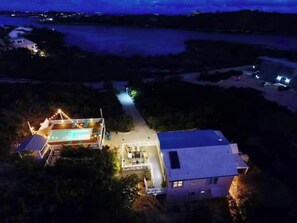 Ein Wohnhaus mit Schwimmbad, überdachter Terrasse und Hauptgebäude.