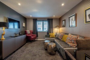 Ein modernes Wohnzimmer mit einer Couch, einem Sessel und einem Couchtisch.