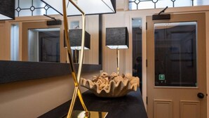 Un interior modern amb una làmpada de terra reflectant, un bol decoratiu i una porta amb panell de vidre.