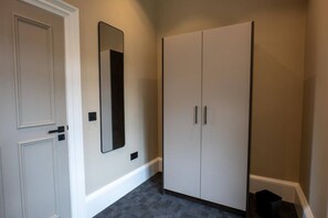 A hallway with a double door, a mirror, and a wardrobe. - Sophisticated Urban Living| Sleek 4-Bedroom Home (Edinburgh)