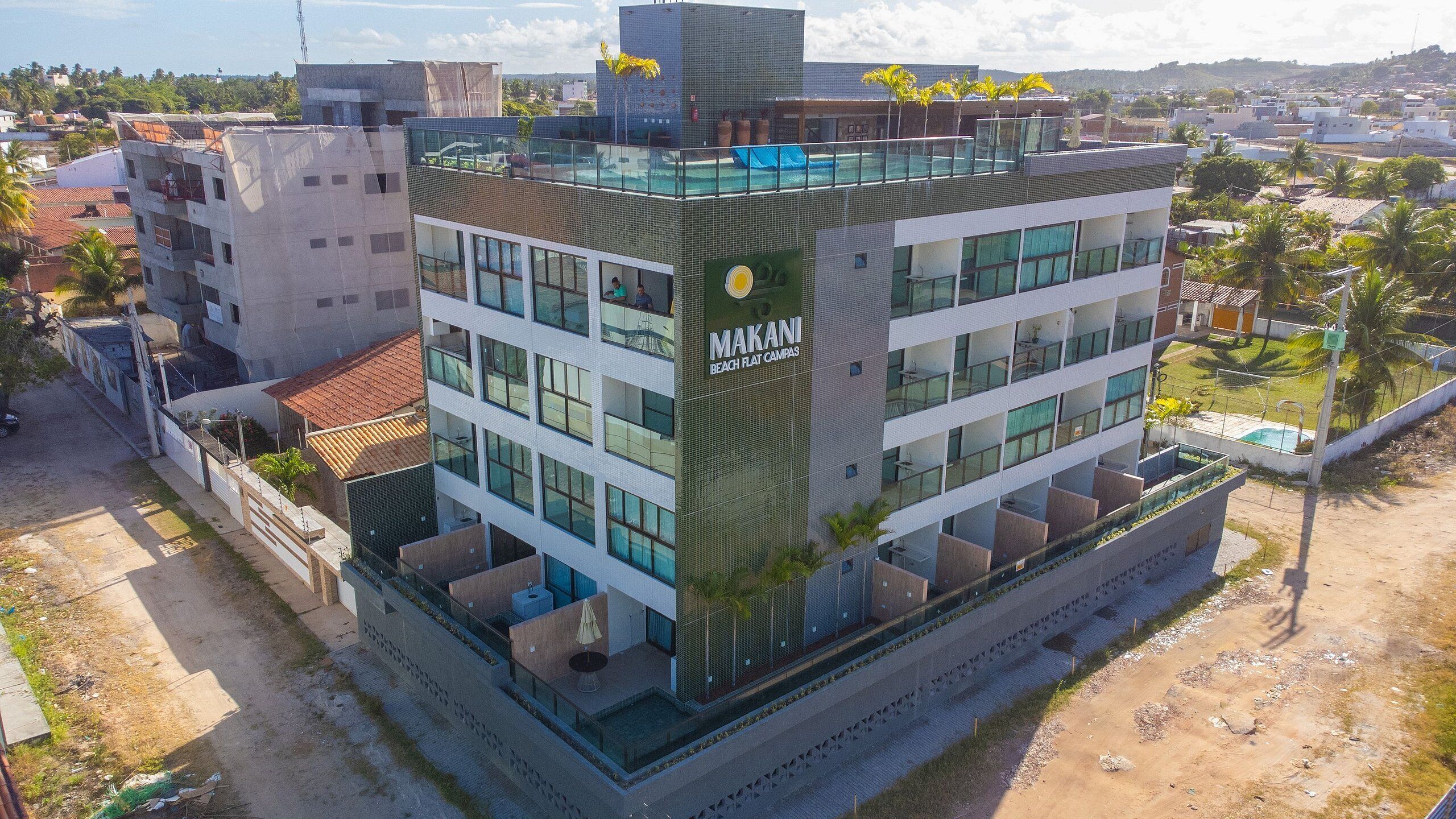 Un immeuble à plusieurs étages, sur lequel on peut voir une enseigne bien visible indiquant « MAKANI BEACH FLAT CAMPAS ».