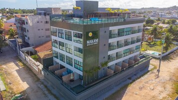 Un edificio de varios pisos con un letrero destacado que dice 'MAKANI BEACH FLAT CAMPAS'.