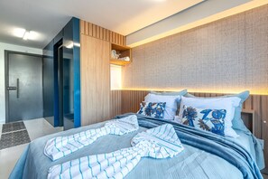 Ein modernes Hotelzimmer mit einem Bett, einem Kleiderschrank und einer eingebauten Schrankwand mit Regalen.