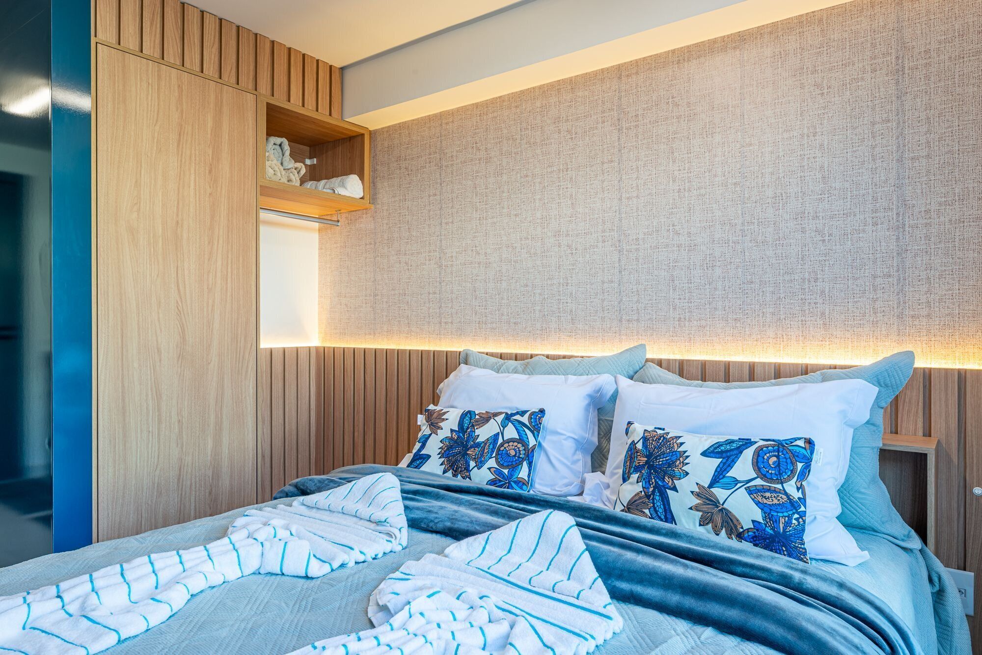 Un dormitorio moderno con cama, almohadas y cabecera.