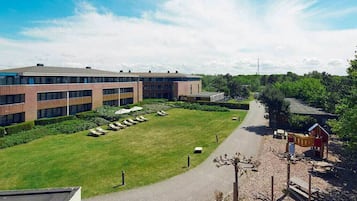 En gård med en bygning, en legeplads og en belagt sti.