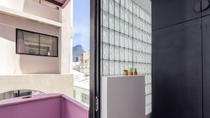 A balcony with a view of a mountain, a window with a curtain, and a door with a handle. - The Urban Nest by Ctha (Cape Town)