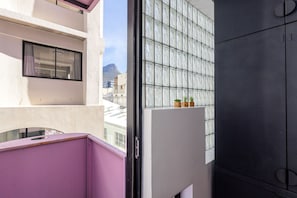 Ein Balkon mit Bergblick, ein Fenster mit Vorhang und eine Tür mit Griff.